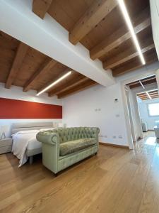 a bedroom with a bed and a green couch at Residenza Della Samaritana in Verona