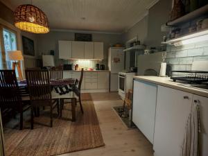 a kitchen with a table and a table and chairs at Tunnelmallinen kaksio järven lähellä, vuokraajalle käytössä myös kajakkikaksikko in Heinola