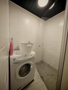 a laundry room with a washing machine in a bathroom at Tunnelmallinen kaksio järven lähellä, vuokraajalle käytössä myös kajakkikaksikko in Heinola