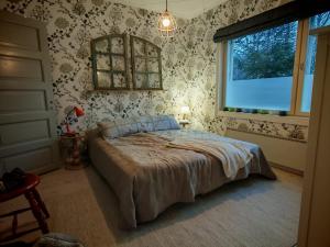 a bedroom with a bed in a room with wallpaper at Tunnelmallinen kaksio järven lähellä, vuokraajalle käytössä myös kajakkikaksikko in Heinola