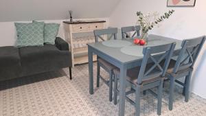 a dining room with a blue table and chairs at MANSARD - Bozsok in Bozsok