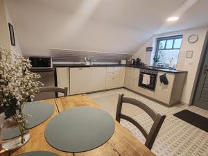 a kitchen with a table and chairs in a room at MANSARD - Bozsok in Bozsok