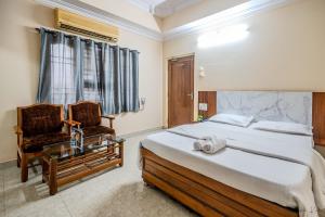 a bedroom with a bed and a chair and a table at Laxman Avenue in Jagdalpur