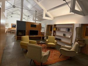 a living room with chairs and a flat screen tv at Casa Vidinha in Faria de Baixo