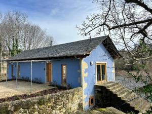 a small blue house with a stone wall at Casa Vidinha in Faria de Baixo
