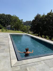 a woman swimming in a swimming pool at Casa Vidinha in Faria de Baixo