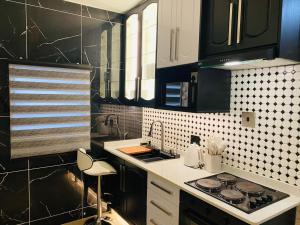 a kitchen with black cabinets and a stove top oven at Royal Lodge in Sibasa