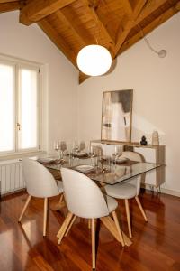 a dining room with a glass table and chairs at Liberty Apartment in Lovere +18 photos