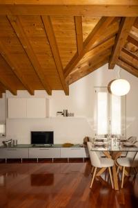 a living room with wooden ceilings and a table and chairs at Liberty Apartment in Lovere