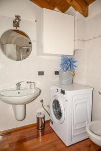 a bathroom with a washing machine and a sink at Liberty Apartment in Lovere