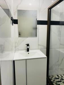 a white bathroom with a sink and a mirror at Royal Lodge in Sibasa
