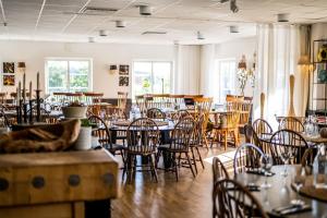 a dining room with tables and chairs and windows at Körunda Golf & Conference Hotel in Ösmo
