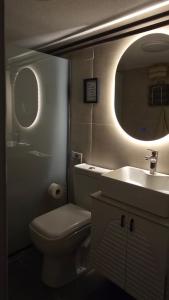 a bathroom with a toilet and a sink and a mirror at Lex Apartments KS in Prizren +25 photos