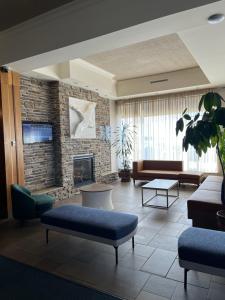 a lobby with a living room with a fireplace at Hotel L'Oie des neiges in Lévis