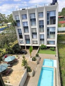 an apartment building with a swimming pool in front of it at Brizelle studio in Ongata Rongai 