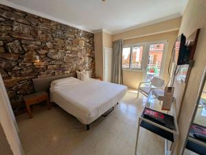 a bedroom with a bed and a stone wall at Hostal Mar del Plata in El Arenal +45 photos