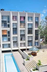 a large apartment building with a swimming pool and a building at Brizelle studio in Ongata Rongai 