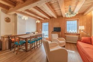 a living room with a dining room table and chairs at Chalet Dolomites Heart in Feder