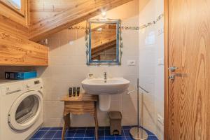 a bathroom with a sink and a washing machine at Chalet Dolomites Heart in Feder +17 photos