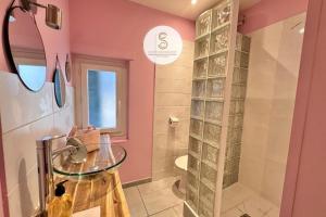 a bathroom with pink walls and a glass shower at Arles Getaway - Le Flamant Vert in Arles +15 photos