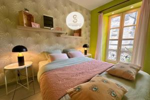 a bedroom with a large bed with pink sheets and a window at Arles Getaway - Le Flamant Vert in Arles