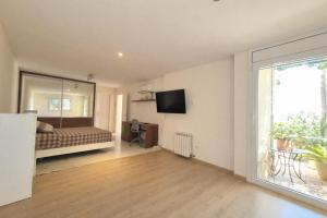 a bedroom with a bed and a tv on the wall at La Marina in Lloret de Mar