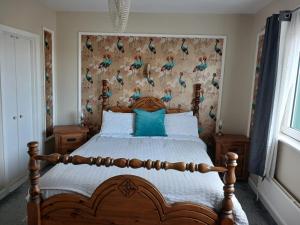 a bedroom with a bed with a wall with birds on it at Ceecliff House in Culdaff