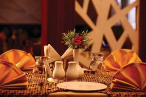 a table with a vase with a flower in it at Hotel Indraprastha, Pattazhy in Avanīsvaram