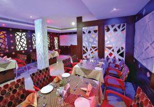 a restaurant with tables and chairs in a room at Hotel Indraprastha, Pattazhy in Avanīsvaram