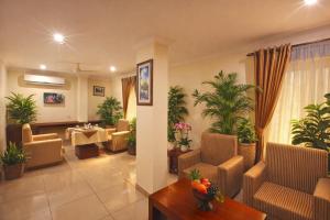a living room with chairs and a table and plants at Hotel Indraprastha, Pattazhy in Avanīsvaram