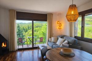 a living room with a couch and a table at Allotjaments Vall de Muntanyes in Molló +35 photos