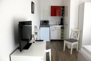 a white kitchen with a desk with a computer on it at Pension Weber in Erfurt