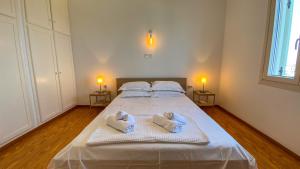 a bedroom with a large white bed with towels at Gaia in Agios Georgios