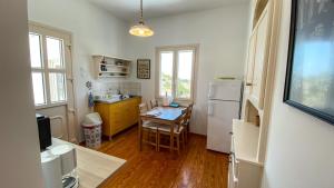 a kitchen with a table and a white refrigerator at Gaia in Agios Georgios