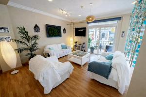 a living room with white furniture and a large window at Hostal Mar del Plata in El Arenal