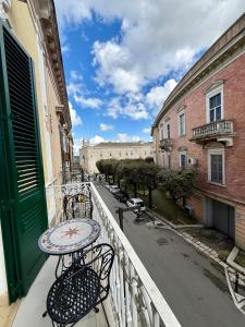a balcony with a table and chairs on a city street at Bellavitarooms-Fiore di Maggio Luxury Suites in Matera