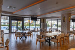 a dining room with tables and chairs and windows at Helena Sea Breeze Apartments - Resort Living with Pools & Full Facilities in Kalecik