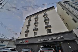 a hotel building with cars parked in front of it at 위드유 호텔 광주역 in Kwangju-yŏk