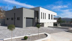 a large white house with a driveway at New Villa Oasis in Imotski