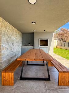 a large wooden table in a room with a brick wall at New Villa Oasis in Imotski
