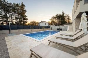 a swimming pool with two loungers and a swimming pool at New Villa Oasis in Imotski