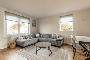 a living room with a couch and a table at Admiralty Lane - No 4 in Elie +23 photos