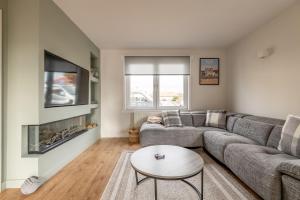 a living room with a couch and a fireplace at Admiralty Lane - No 4 in Elie
