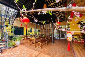 a restaurant with tables and chairs in a building at Peace Homestay Hoa Lư in Xuân Sơn