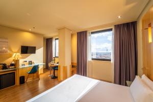 a hotel room with a bed and a desk at Abba Madrid in Madrid