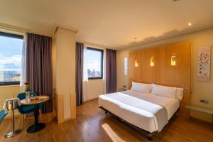 a bedroom with a large white bed and a table at Abba Madrid in Madrid +47 photos