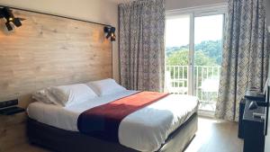 a bedroom with a bed and a large window at Hotel & Appartements Acqua Dolce in Porticcio