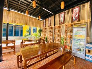 a dining room with wooden tables and shelves of books at Peace Homestay Hoa Lư in Xuân Sơn