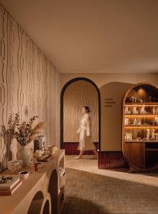 a woman is walking through a room with a table at Villa Sahrai, a Member of Design Hotels in Casablanca +43 photos