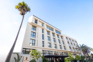a palm tree in front of a white building at Villa Sahrai, a Member of Design Hotels in Casablanca